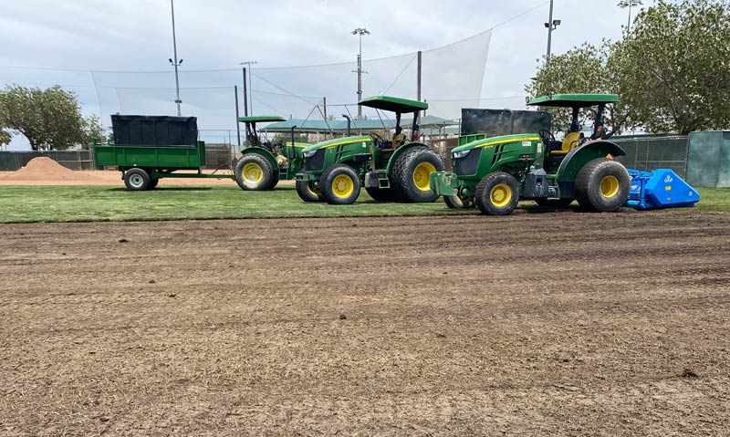 Natural grass removal progress on softball field.